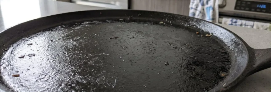 Gros plan d'une surface de plaque en fonte pour crêpière montrant sa texture mate et légèrement huilée
