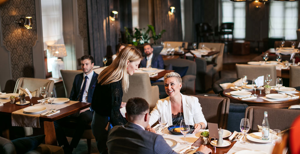 Configuration en U d'une salle privée de restaurant pour un séminaire d'entreprise avec matériel de présentation